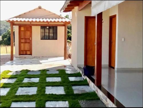 uma casa com um relvado verde em frente em Chalé sossego em Pirenópolis