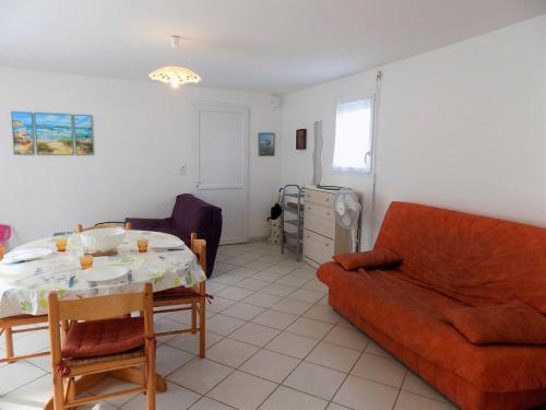 a living room with a couch and a table at Saint Palais sur Mer - MAISON MITOYENNE - cour privée - CENTRE VILLE in Saint-Palais-sur-Mer