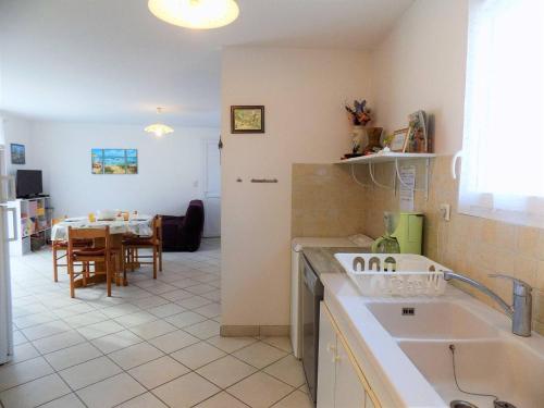 a kitchen with a sink and a table in a room at Saint Palais sur Mer - MAISON MITOYENNE - cour privée - CENTRE VILLE in Saint-Palais-sur-Mer