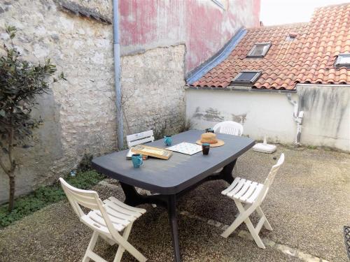 a table and chairs sitting on a patio at Saint Palais sur Mer - MAISON MITOYENNE - cour privée - CENTRE VILLE in Saint-Palais-sur-Mer