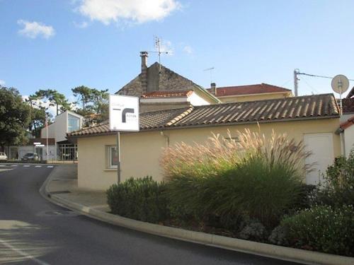 a house with a sign on the side of a street at Saint Palais sur Mer - MAISON MITOYENNE - cour privée - CENTRE VILLE in Saint-Palais-sur-Mer