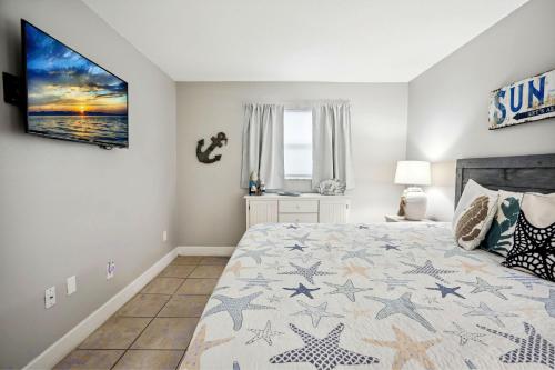 1 dormitorio con 1 cama y TV en la pared en Holiday Villas II 407 Premier, en Clearwater Beach