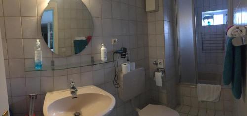 a bathroom with a sink and a mirror at Dormitorium Kaarst Wohnraum auf Zeit in Kaarst