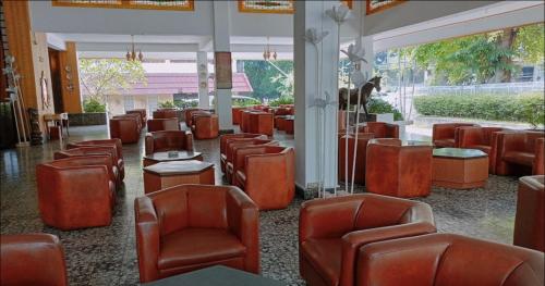 una fila de sillas y mesas en una sala de espera en Siantar Hotel Pematangsiantar, en Pematangsiantar