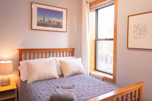 une chambre avec un lit avec des oreillers blancs et une fenêtre dans l'établissement 2 Bedroom Apt with 3 Beds - Friends & Family, à New York