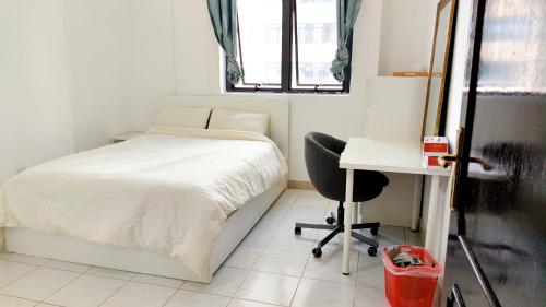 een slaapkamer met een bed, een bureau en een stoel bij Ms. Zhang Apartment in Abu Dhabi