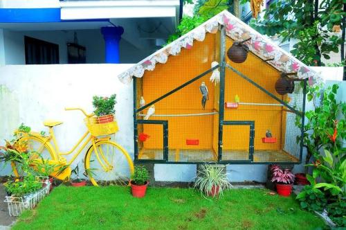 a bird house with a bike in front of a house at El Casa Homestay in Cochin