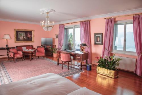 ein Wohnzimmer mit rosa Wänden, einem Tisch und Stühlen in der Unterkunft Hotel Victoria Glion in Montreux