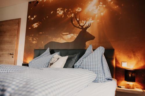 a bedroom with a bed with a picture of a deer on the wall at Wohnung Schrödelstein in Lenggries