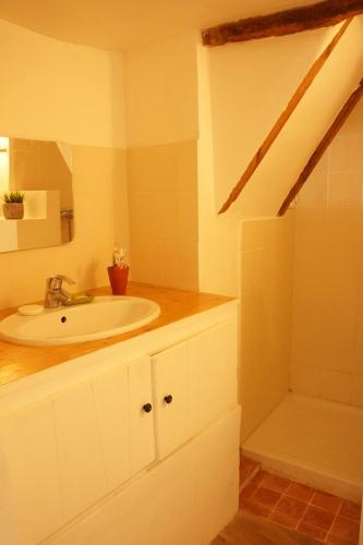 une salle de bain blanche avec un lavabo et une douche dans l'établissement Longo Mai, à Apt