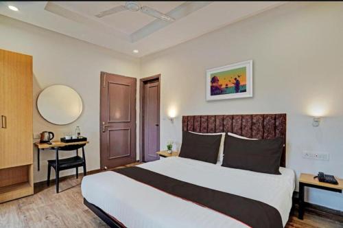 Habitación de hotel con cama grande y escritorio. en Tipsyy Inn 018, en Gurgaon