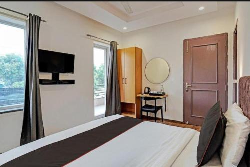 1 dormitorio con 1 cama, TV y ventana en Tipsyy Inn 018, en Gurgaon