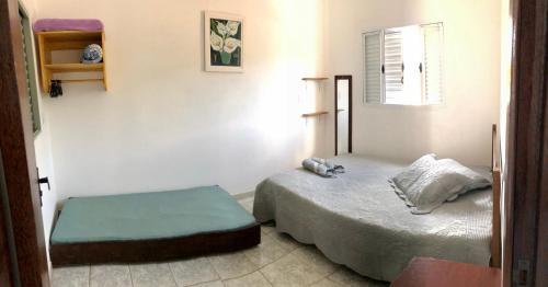 um pequeno quarto com uma cama e uma janela em Serra da Canastra - Casa em Vargem Bonita/MG em Vargem Bonita