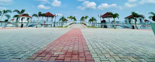 a brick road leading to a playground with palm trees at LOTUS in Colonelbāri