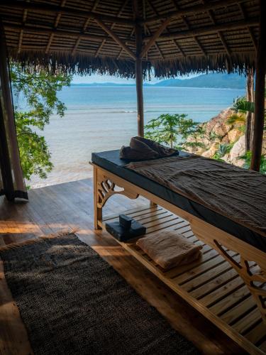 a bed in a hut with a view of the ocean at Diana Lodge in Ankify