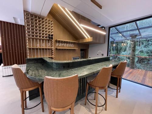 a kitchen with a large counter with chairs around it at Pousada Encontro das Águas in Gonçalves