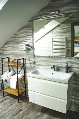 a bathroom with a sink and a large mirror at POKOJE GOŚCINNE U MIKOŁAJA in Pękanino