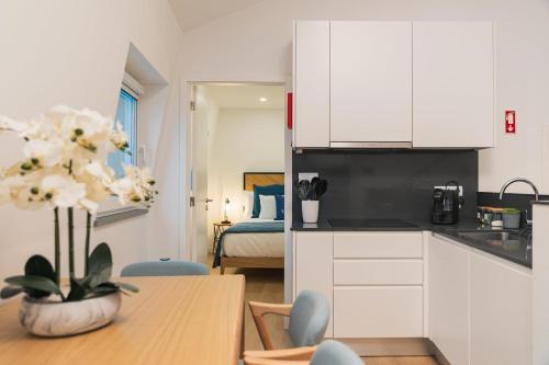 a kitchen with a table and a room with a bed at Varanda Azul - Lookout Loft (City Centre) in Ponta Delgada