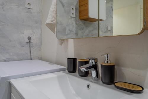 a bathroom with a sink with two coffee cups on it at Full equipment designed apartment in the heart of Budapest for 4 people in Budapest