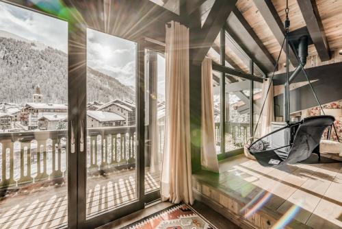 a room with large windows with a view of a city at Hotel & Spa Le Val d'Isère in Val dʼIsère