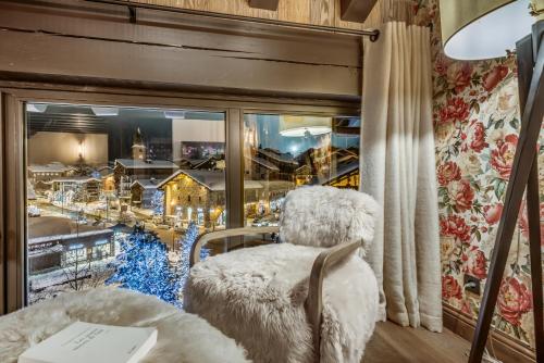 a room with two chairs and a window with a view at Hotel & Spa Le Val d'Isère in Val dʼIsère