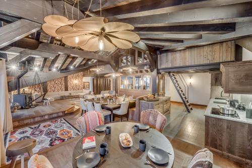 a dining room with tables and chairs and a chandelier at Hotel & Spa Le Val d'Isère in Val dʼIsère