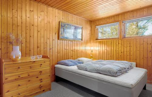 ein Schlafzimmer mit einem Bett und einer Holzwand in der Unterkunft Gorgeous Home In Lkken With Kitchen in Løkken
