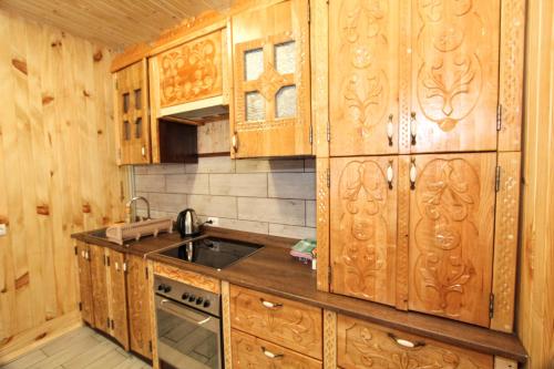 una cocina con armarios de madera y fregadero en Котедж "На Дачній" en Yaremche