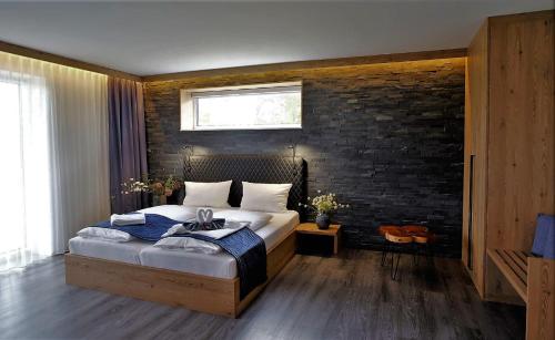 um quarto com uma cama e uma parede de tijolos em Privat & Boutique Hotel Plauer See em Funfseen