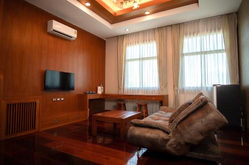 sala de estar con sofá y mesa en HUAN CHOM JAN Hometel at Lampang 