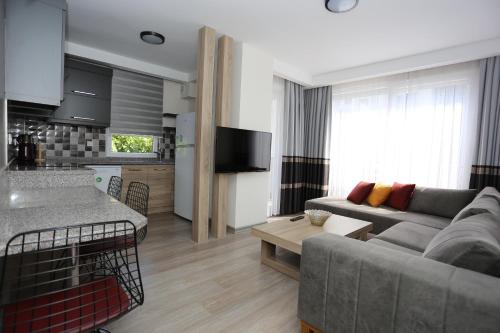 a living room and kitchen with a couch and a table at Elanis Suites in Antalya