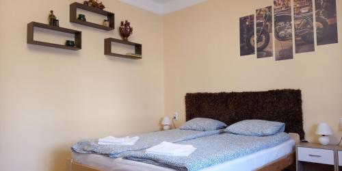 sypialnia z łóżkiem i 2 zdjęciami na ścianie w obiekcie Móricz Vendégház w mieście Sárospatak