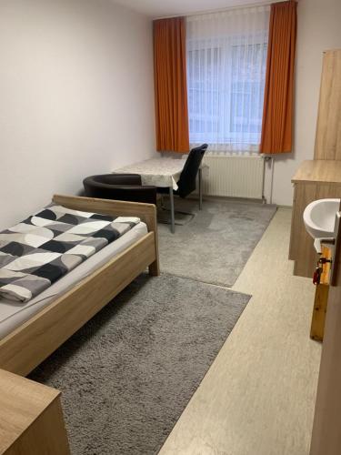 Ein Zimmer mit einem Bett und einem Waschbecken sowie einem Bett mit einem sidx sidx sidx. in der Unterkunft Monteure & Handwerker einfach, unkompliziert und preiswert in Alsfeld in Alsfeld