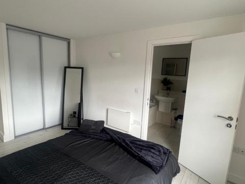 a bedroom with a large bed and a mirror at Broadway’s Canterbury City Escape in Canterbury