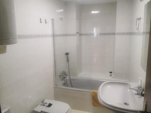 a bathroom with a toilet and a sink and a tub at Mérida Monumental y Vacacional in Merida