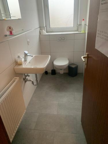 ein Bad mit einem Waschbecken, einem WC und einem Fenster in der Unterkunft Monteure & Handwerker einfach, unkompliziert und preiswert in Alsfeld in Alsfeld