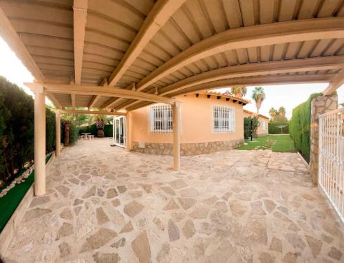an outdoor patio with a wooden pergola at Impresionante villa con piscina in Oliva