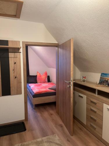 um pequeno quarto com uma cama no sótão em Ferienwohnung LoWu em Hagen