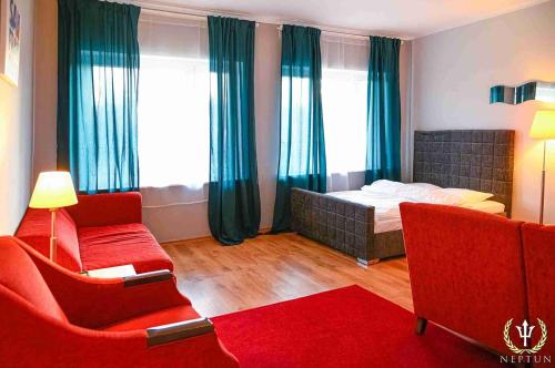ein Schlafzimmer mit einem Bett, einem Sofa und einem Stuhl in der Unterkunft Hotel i Restauracja - Jastrzębia Góra in Puck