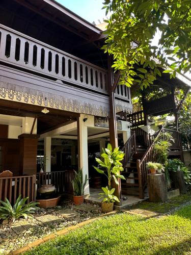 a house with stairs and plants in front of it at SJ House in Chiang Mai