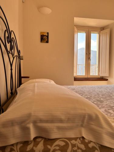 a white bed in a room with a window at B&B Convivium in Stazzema