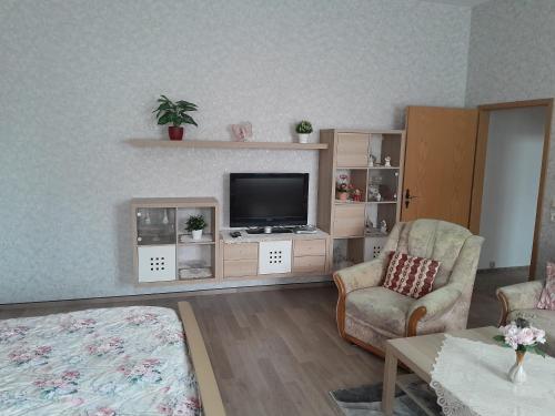 a living room with a tv and a couch and a chair at Ferienwohnung Mantei in Altentreptow