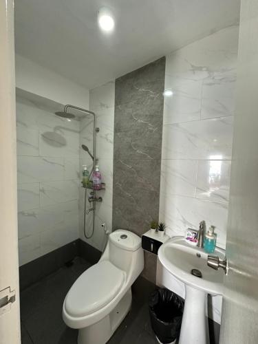 biała łazienka z toaletą i umywalką w obiekcie D Villa Nueva's Beach House w mieście Lobo