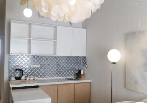 a kitchen with a sink and a chandelier at Discovery Saipan Hotel in Garapan