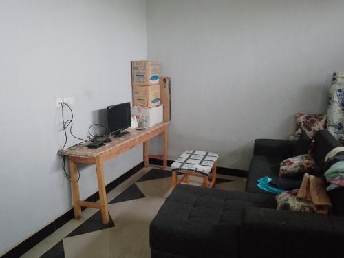 ein Wohnzimmer mit einem Schreibtisch und einem Computer darauf in der Unterkunft Misyie's HomeStay in Sao Hill
