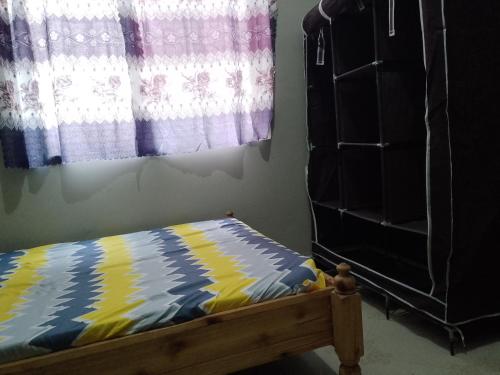 a bedroom with a bed and a dresser and a window at Misyie's HomeStay in Sao Hill