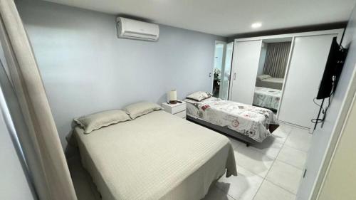 a small bedroom with a bed and a mirror at Apto Joao Pessoa/Cabedelo in Cabedelo