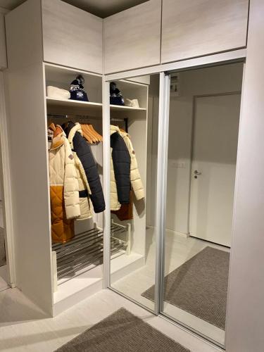 ein begehbarer Kleiderschrank mit Glastüren und Kleidung in der Unterkunft Tilava kaksio- Keskusta- Autopaikka in Rovaniemi