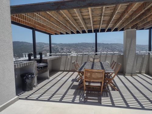 a patio with a table and chairs on a balcony at Departamento 2 Dormitorios Valparaiso in Valparaíso
