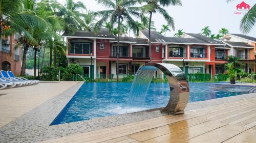 Heritage Nirvana Villa - 4BHK, Goa في كالانغيُت: نافورة مياه وسط مسبح